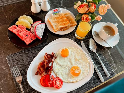 a table topped with plates of breakfast foods and coffee at Ramada Sukhumvit Soi Eleven in Bangkok