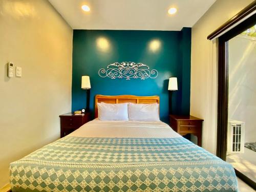 a bedroom with a large bed with a blue wall at Paradores de Vigan in Vigan