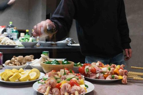 a person standing in front of a buffet of food at 空翠 - Kusui 1日1組限定の貸切宿 in Karatsu