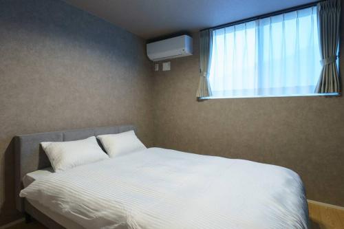 a bedroom with a bed and a window with a television at 空翠 - Kusui 1日1組限定の貸切宿 in Karatsu