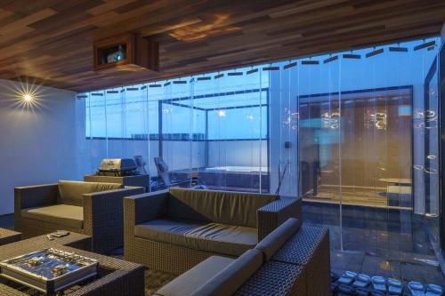 a living room with a couch and a glass wall at 空翠 - Kusui 1日1組限定の貸切宿 in Karatsu