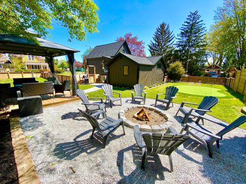 a group of chairs and a fire pit in a yard at Stylish Downtown Kingsville Getaway with Putting Green, Firepit & Games in Kingsville