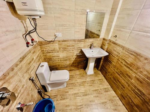a bathroom with a toilet and a sink at White Rose Hotel in Manāli