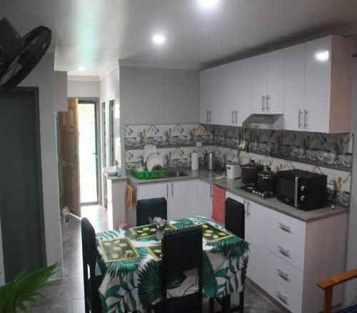 a kitchen with a table and a table and chairs at Mount Olivet House in Suva