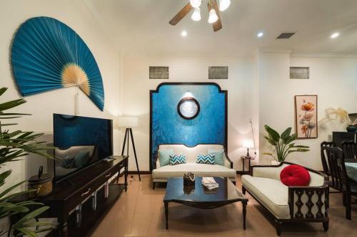 a living room with a couch and a clock on the wall at Indochine 4Bedrooms house Heart Old Quarter by SSens Homes in Hanoi