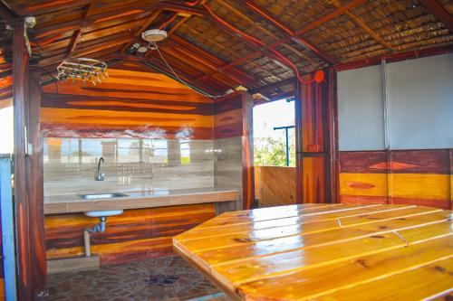 a kitchen with wooden walls and a wooden table at Casa de Madera The Wooden House in Cabuyao