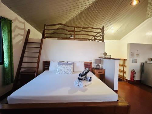 Tongatok Cliff Resort في مامباجاو: غرفة نوم مع سرير بطابقين مع سلم