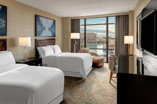a hotel room with two beds and a flat screen tv at The Westin Huntsville in Huntsville