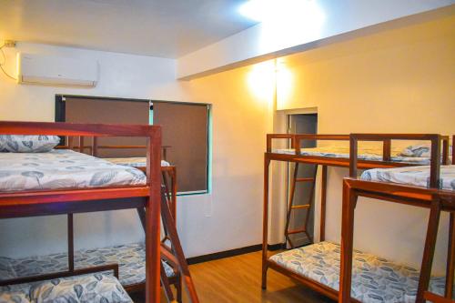a room with three bunk beds and a mirror at Casa de Madera The Wooden House in Cabuyao
