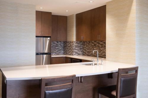 a kitchen with a white counter top and wooden cabinets at The Westin Huntsville in Huntsville
