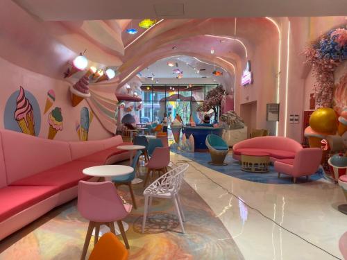 a room with a pink couch and chairs and tables at Flamingo Hải Tiến - Căn góc 2 Phòng - View 2 mặt biển in Thanh Hóa