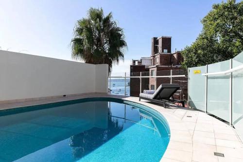 a swimming pool with a chair next to a fence at Studio Apartment Elizabeth Bay Potts Point in Sydney