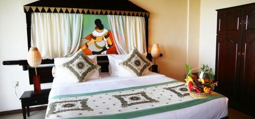 a bedroom with a large bed with a woman on it at Randholee Resort & Spa in Kandy