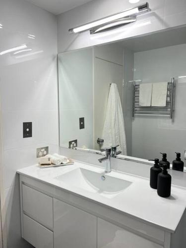 a bathroom with a sink and a large mirror at Studio Apartment Elizabeth Bay Potts Point in Sydney