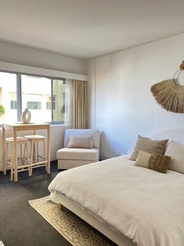 a bedroom with a bed and a table and a chair at Studio Apartment Elizabeth Bay Potts Point in Sydney