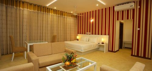 a living room with a couch and a bed in a room at Randholee Resort & Spa in Kandy