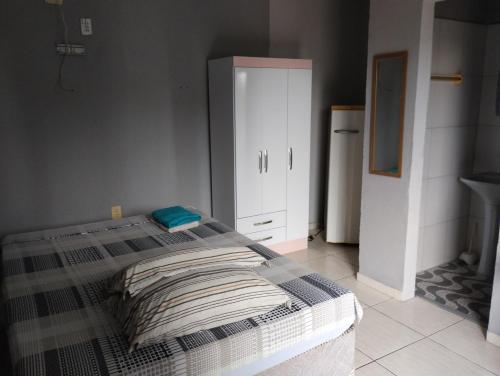 a bedroom with a bed and a white cabinet at Residencial Andréa House in Manaus