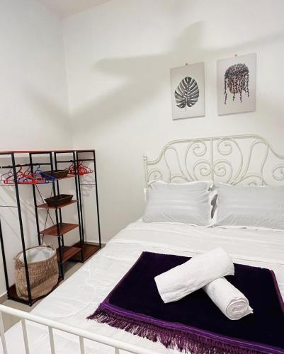 a bedroom with a bed with two towels on it at Resthouse Asyura in Malacca