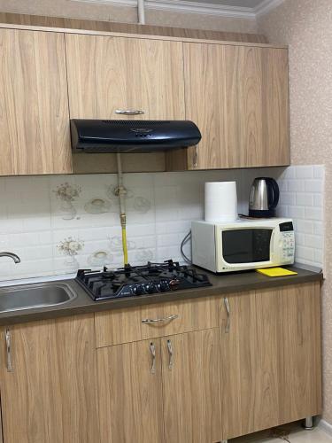 uma cozinha com um fogão e um micro-ondas em Apartament Chisinau str.Cuza Voda em Chişinău