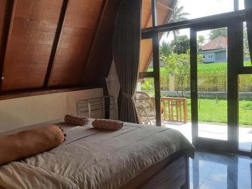 a bedroom with a bed and a large window at D' Carasti Bungalow in Masbagik