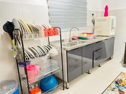 a kitchen with a sink and a counter with dishes at Resthouse Asyura in Melaka