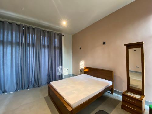 - une chambre avec un lit et une grande fenêtre dans l'établissement Sunset Escape, à Homagama