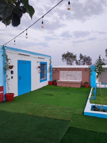 a house with a green yard with a blue door at استراحه ابو فهد in Al Qurayn