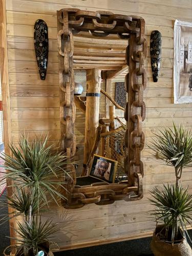 a mirror on the wall of a room with plants at Rakši in Cēsis