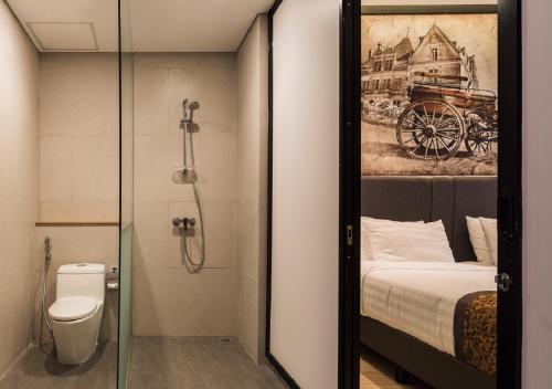a bathroom with a shower and a bed and a toilet at Allura Azana Resort Tawangmangu in Tawangmangu