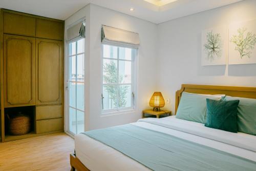 a bedroom with a large bed and a window at Casa Amarta Canggu - Boutique Lofts & Detox SPA in Canggu