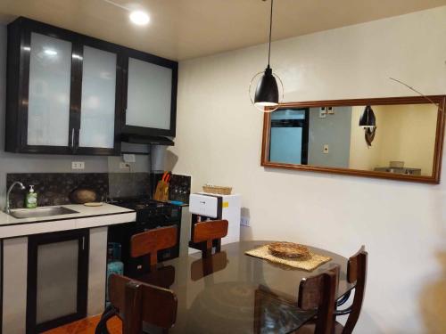 eine Küche mit einem Tisch, einem Waschbecken und einem Spiegel in der Unterkunft Z&j Transient House in Butuan