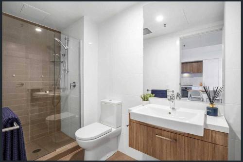 ein Bad mit einem WC, einem Waschbecken und einer Dusche in der Unterkunft Luxe Cityscape Living in Adelaide