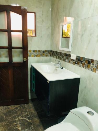 y baño con lavabo y aseo. en CASA DE CAMPO HOSPEDAJe, en Ambato