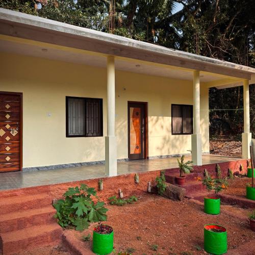 una casa con barriles verdes delante de ella en Wild Village Stay Gokarna en Gokarna