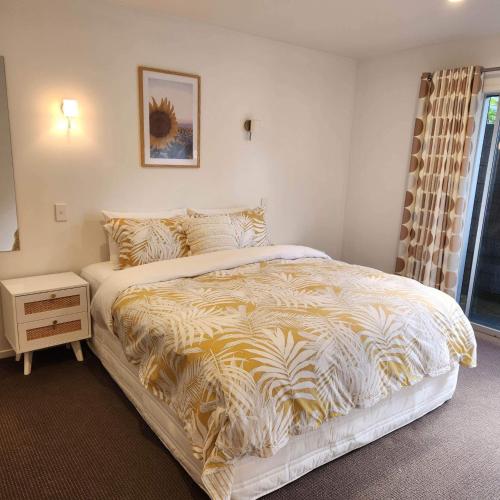 a bedroom with a large bed with a yellow and white comforter at Seascape in Langs Beach