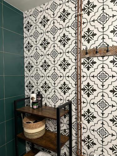 uma casa de banho com uma parede em azulejo preto e branco em Rakši em Cēsis