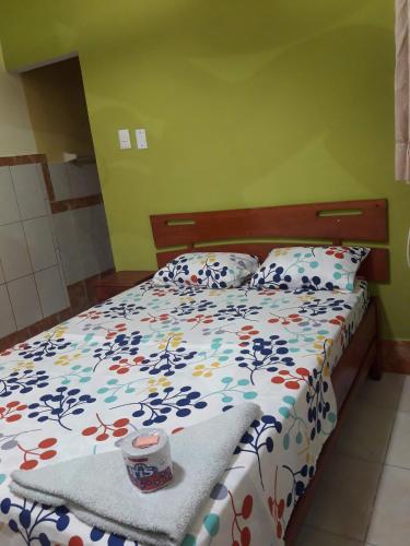 sypialnia z łóżkiem z kołdrą kwiatową w obiekcie Hostal Real Center w mieście Iquitos