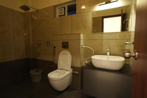 a bathroom with a toilet and a sink at Mesteria Inn Wayanad in Wayanad