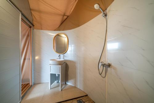La salle de bains est pourvue d'un lavabo et d'un miroir. dans l'établissement The Dewi Bedugul, à Bedugul