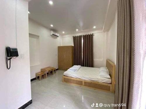 a bedroom with a bed and a phone in a room at Homeatay & Apartment CHÂU SƠN in Vung Tau