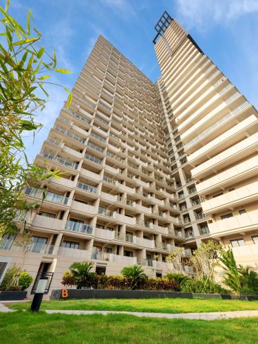 two tall white apartment buildings with a green lawn at JD POLMAN Hotel in Phnom Penh