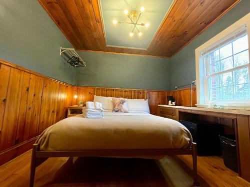 Skyline Village Inn في Spruce Pine: غرفة نوم بسرير كبير بسقف