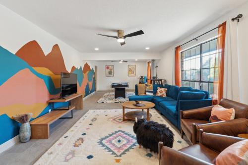 a living room with a blue couch and a cat in it at Central BBQ Haven - 4bd - Games - Outdoor Movie in Albuquerque