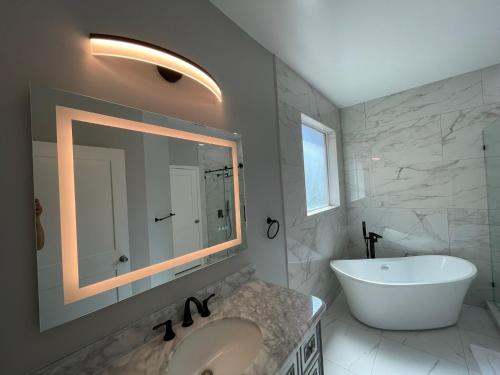 a bathroom with a tub and a sink and a mirror at Family vacation home by Disney in Davenport