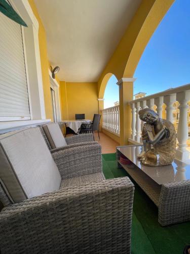 a living room with wicker chairs and a table at Home S&F- Algorfa in Algorfa