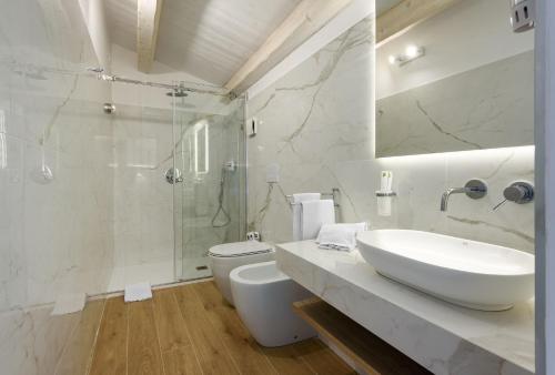 a bathroom with a sink and a toilet and a shower at Andromeda Hotel in San Vito lo Capo