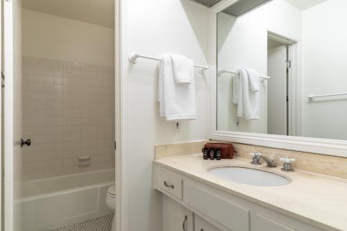 a white bathroom with a sink and a mirror at Bay View II by AvantStay Ocean View Mission Beach Home on the Sand in San Diego