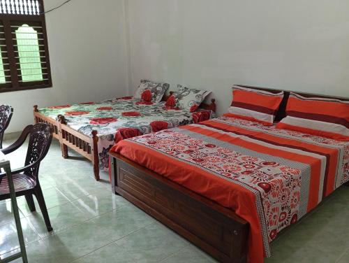 Nallur Mylooran Arangam في جافنا: غرفة نوم بسريرين وطاولة وكراسي