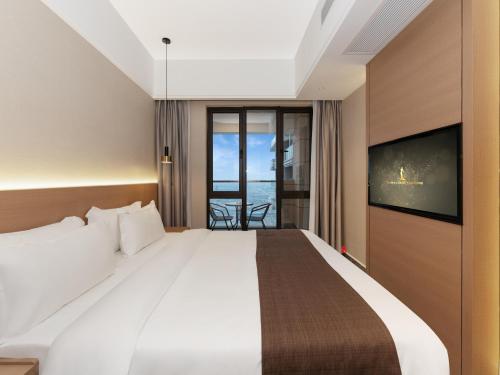 a hotel room with a large bed and a tv at JD POLMAN Hotel in Phnom Penh