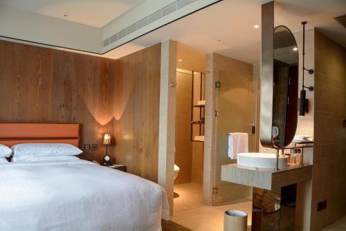 una camera con un grande letto e un lavandino di Sheraton Taitung Hotel a Città di Taitung